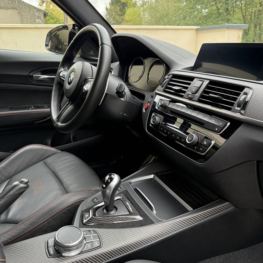 Console centrale carbone d'une BMW M2 après nettoyage