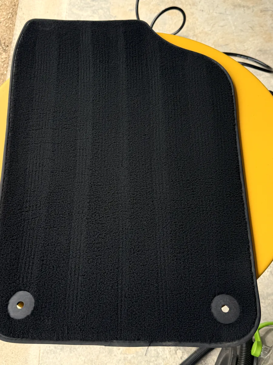 Le même tapis après shampoing, noir profond et fibres relevées